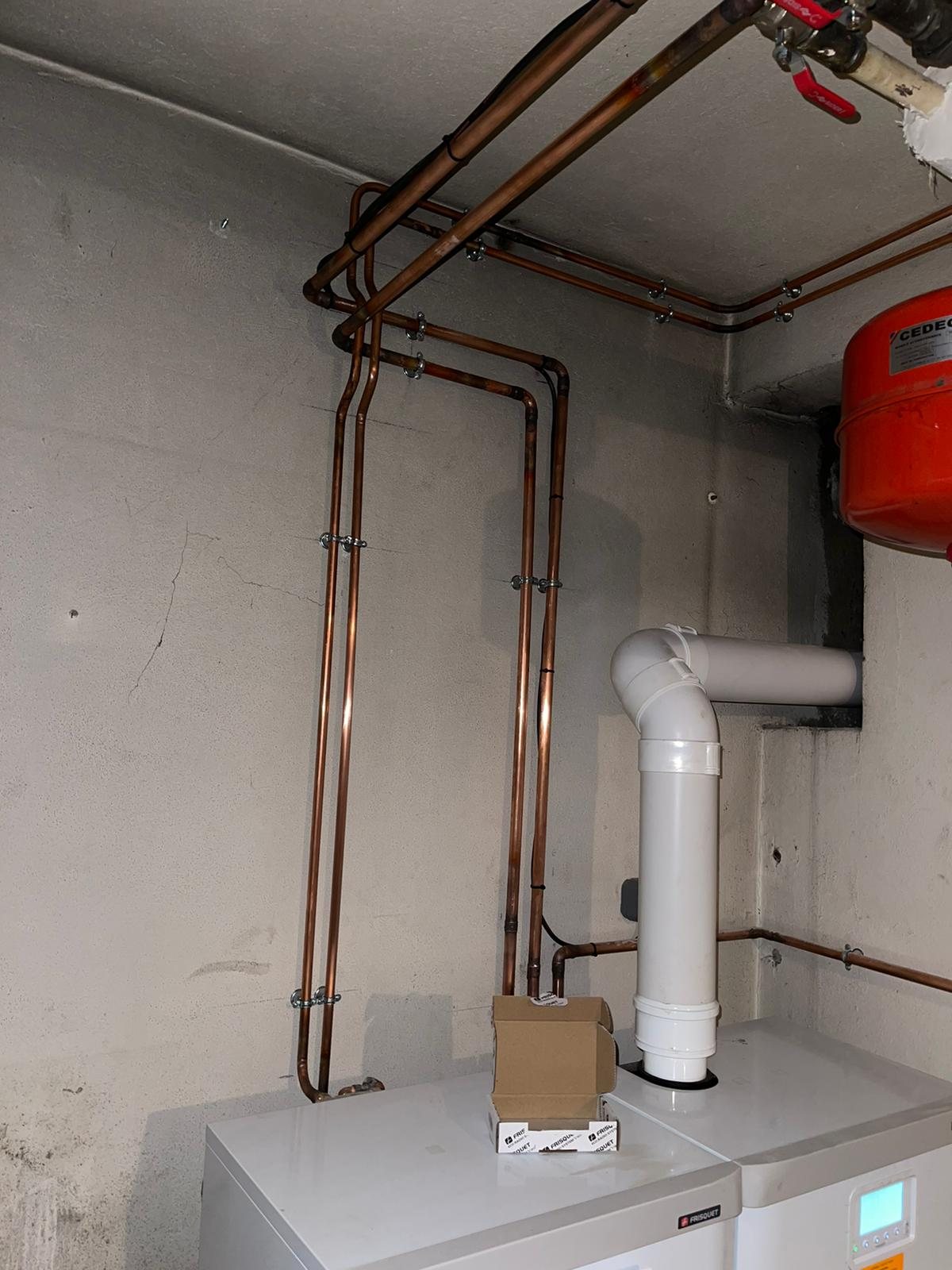 Réseau de tuyauterie cuivre soigneusement fixé au mur et au plafond