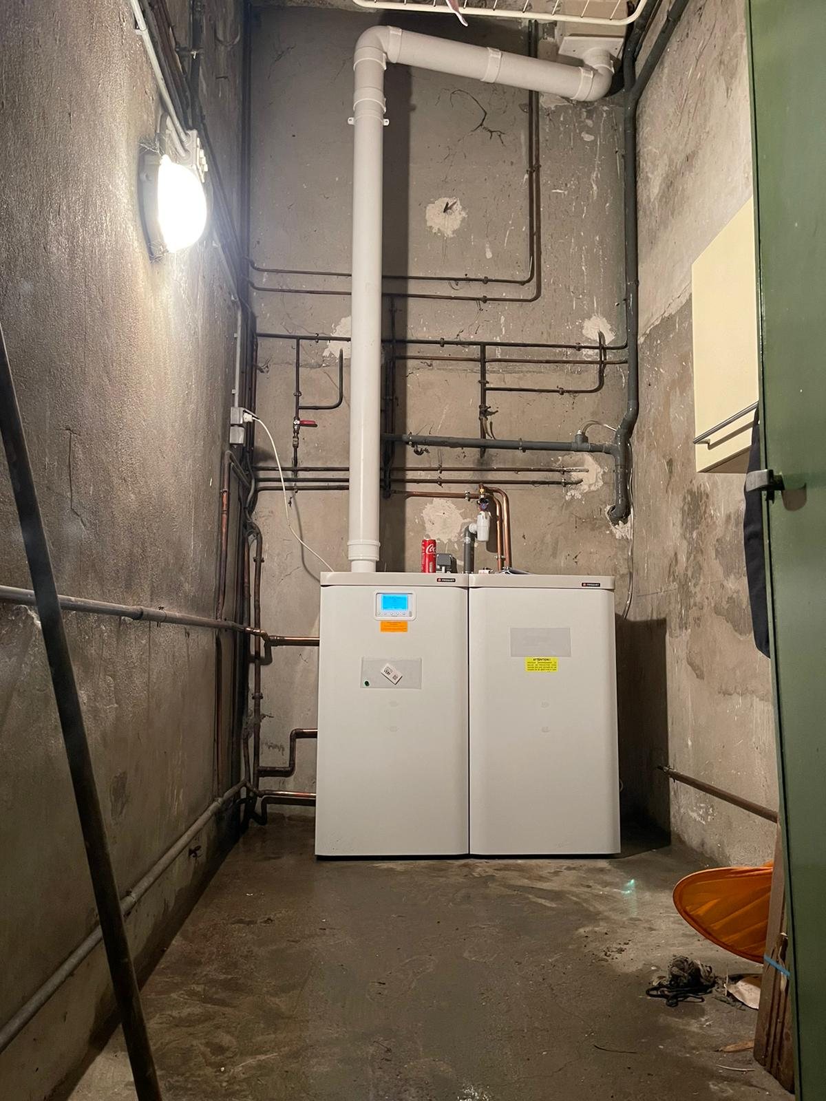 Deux chaudières Frisquet installées dans un local technique avec conduit d'évacuation